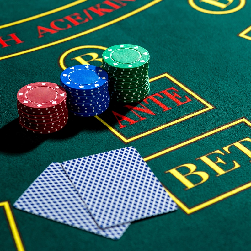 Poker chips and playing cards on a green casino table with "ANTE" and "BET" marked areas.