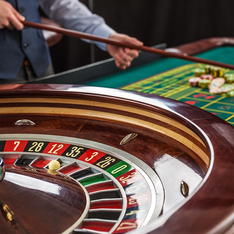 Close-up of a roulette wheel and betting table in a casino.